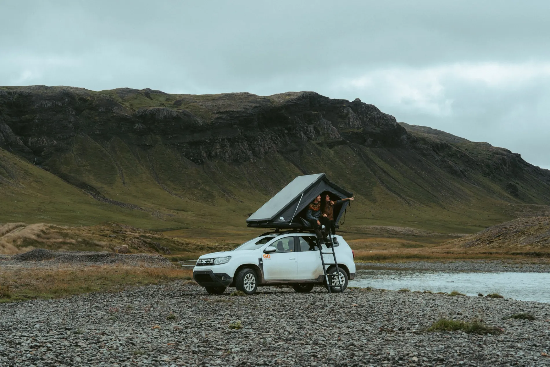 Couple in a Go Campers 4x4 rooftop tent camper beside a river in the Icelandic highlands